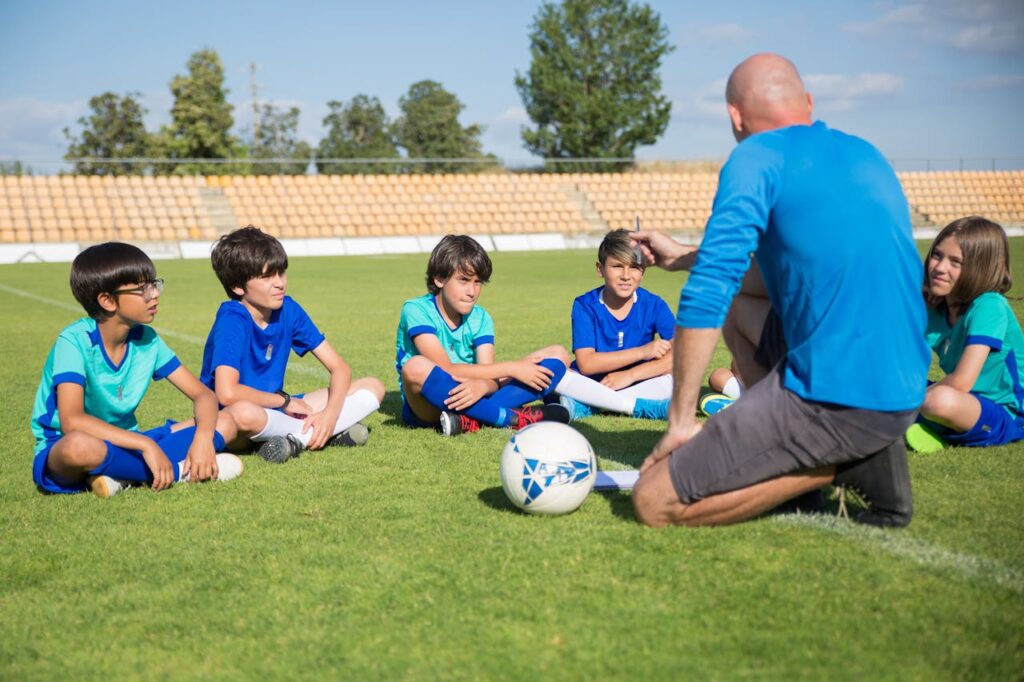 Children gather for a soccer coaching session on a sunny day in Portugal.